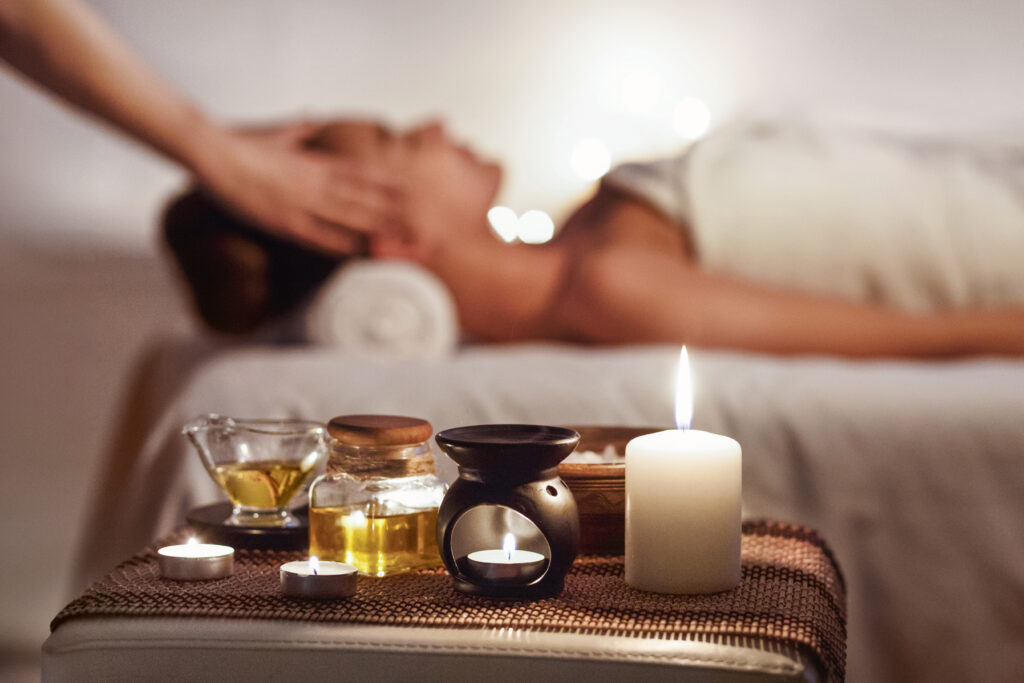 Aroma Spa. Girl Enjoying Massage In Luxury Spa With Candles On Foreground
